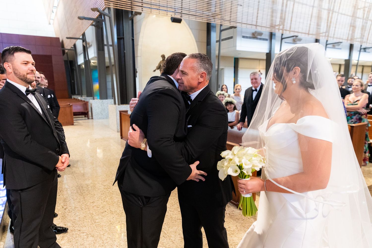 Wedding party interaction during church ceremony with joyful expressions.