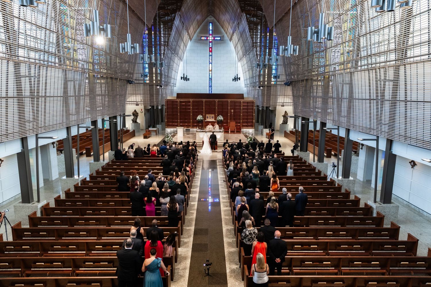 Beautiful church interior with stained glass and vaulted gothic arches during a wedding ceremony.