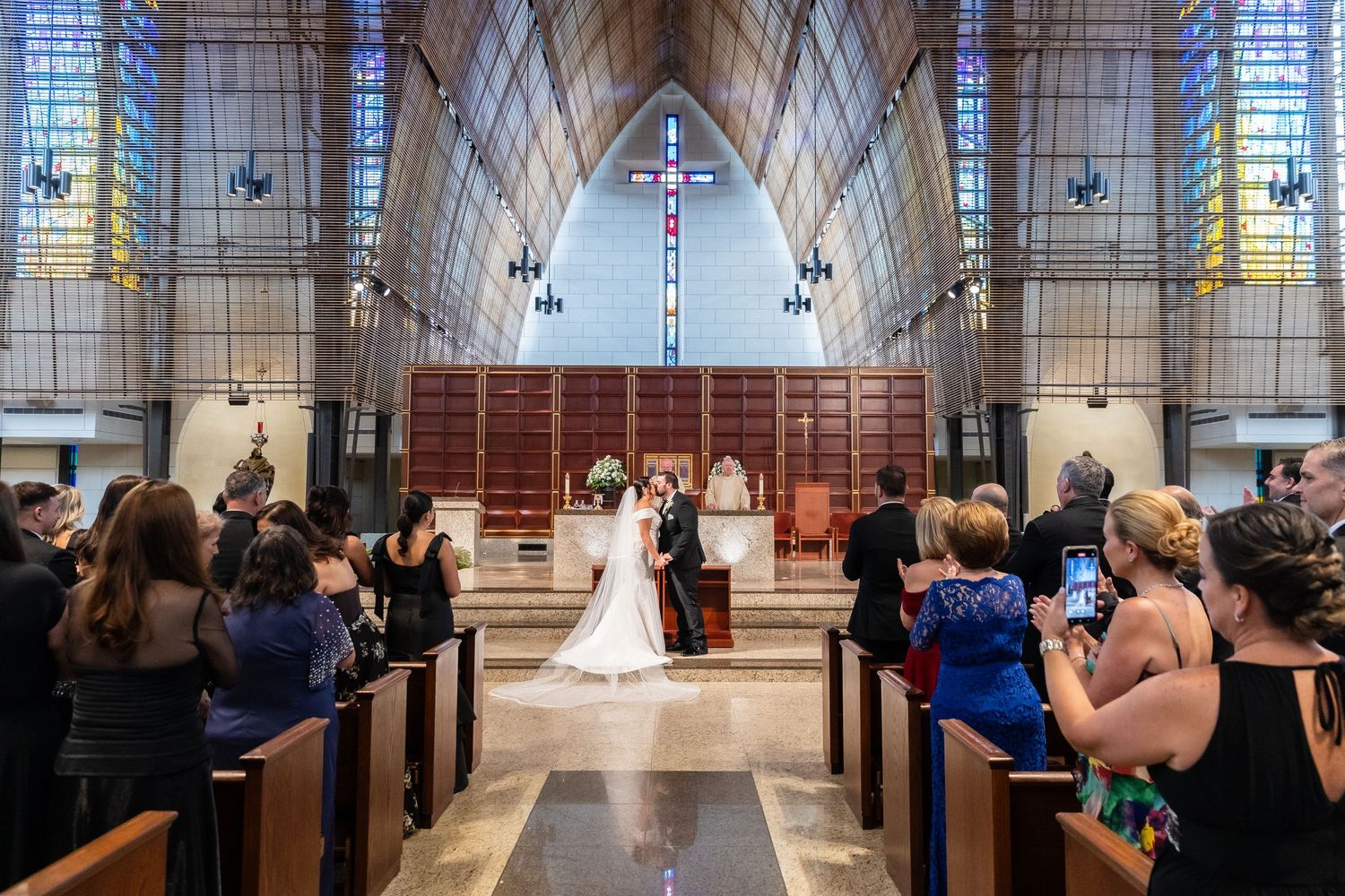 Panoramic view of a contemporary church interior with angular architecture and high glass ceilings for a wedding service.