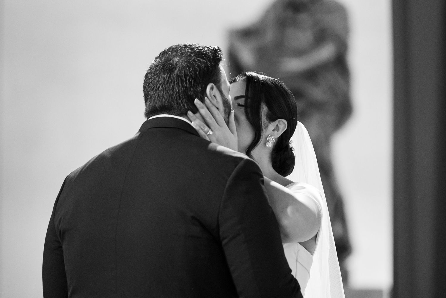 Black and white photograph showing romantic moment between couple.