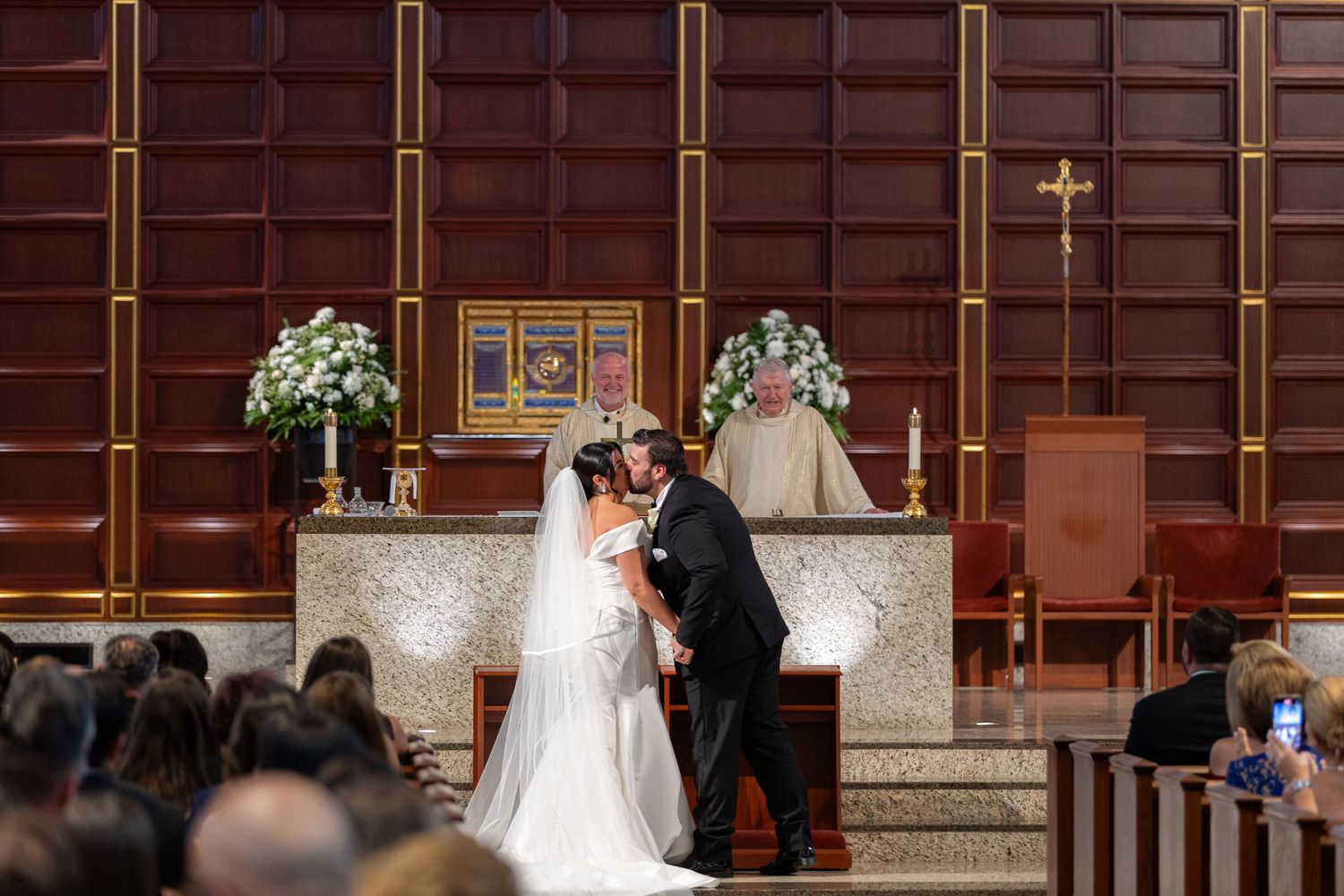 Traditional church wedding ceremony with wooden pews and stained glass windows.
