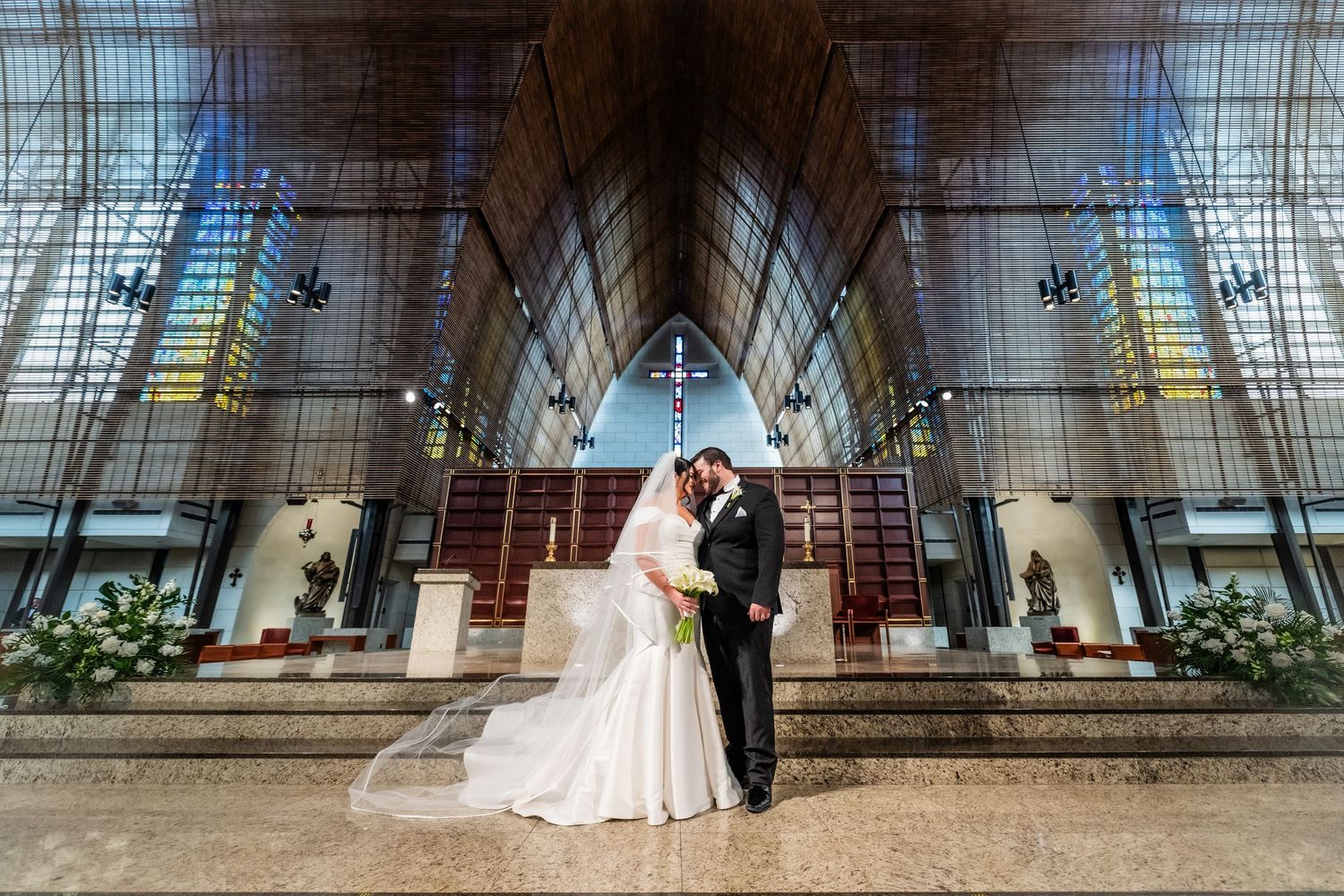 Modern church interior with dramatic lighting and architectural details during wedding ceremony.
