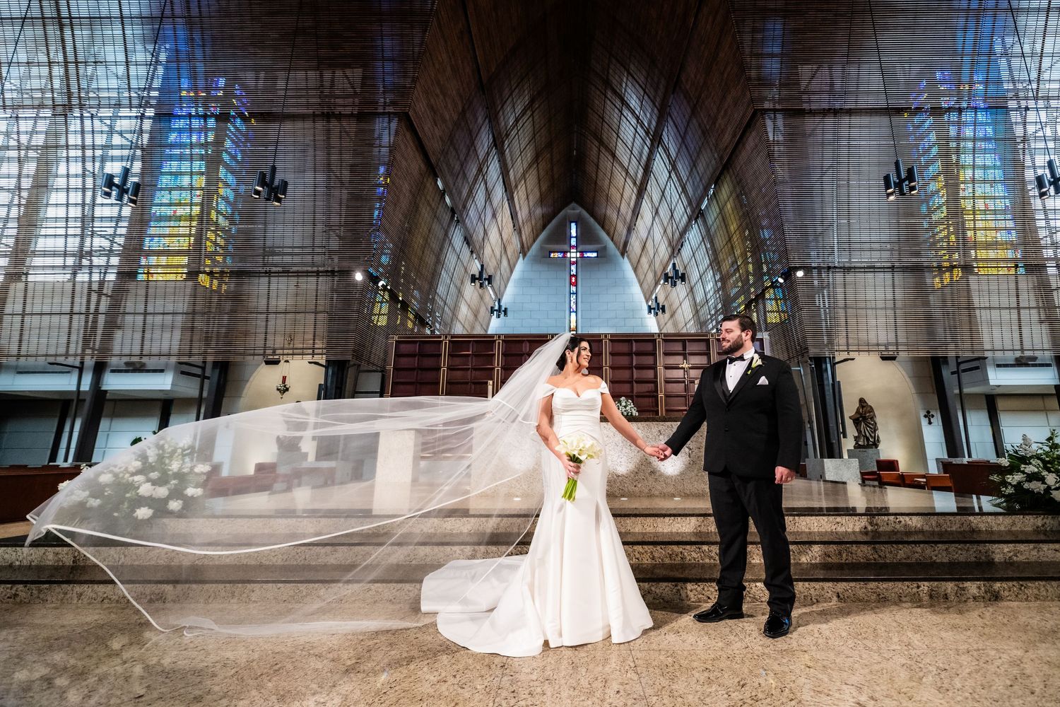 Cathedral interior with dramatic lighting and architectural details during wedding ceremony.