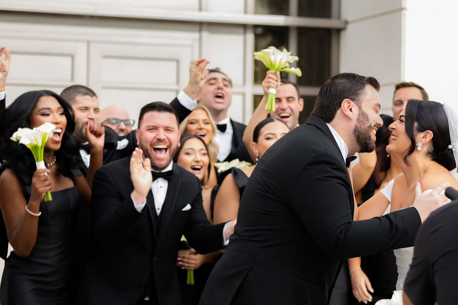 Wedding party celebrates with joyful expressions during reception festivities.