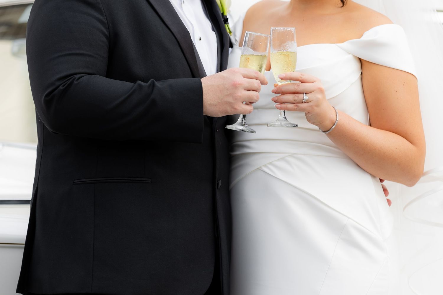 Close-up details of formal wedding attire including black tuxedo and white bridal gown.