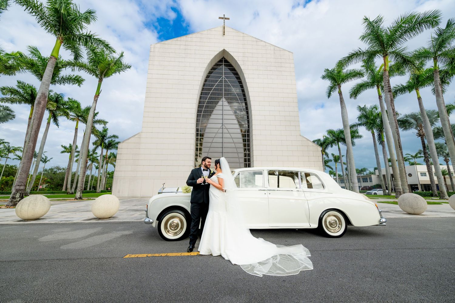Classic white church with palm trees and vintage car for wedding photography.