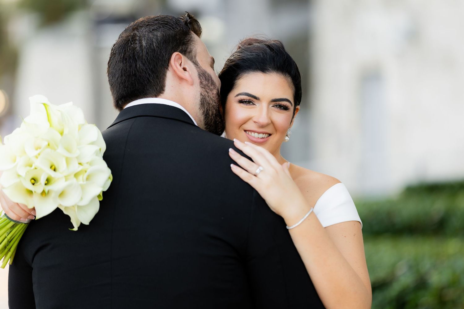 Elegant outdoor wedding portrait with white floral bouquet.