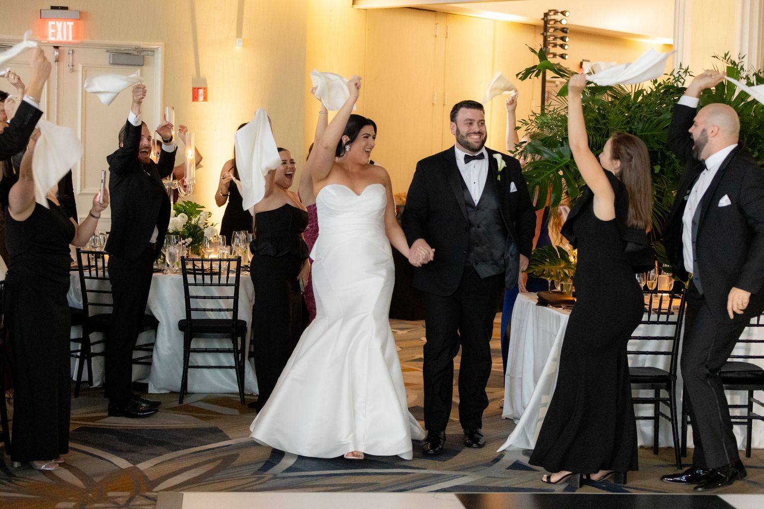 Wedding reception dance floor filled with guests celebrating in formal attire.