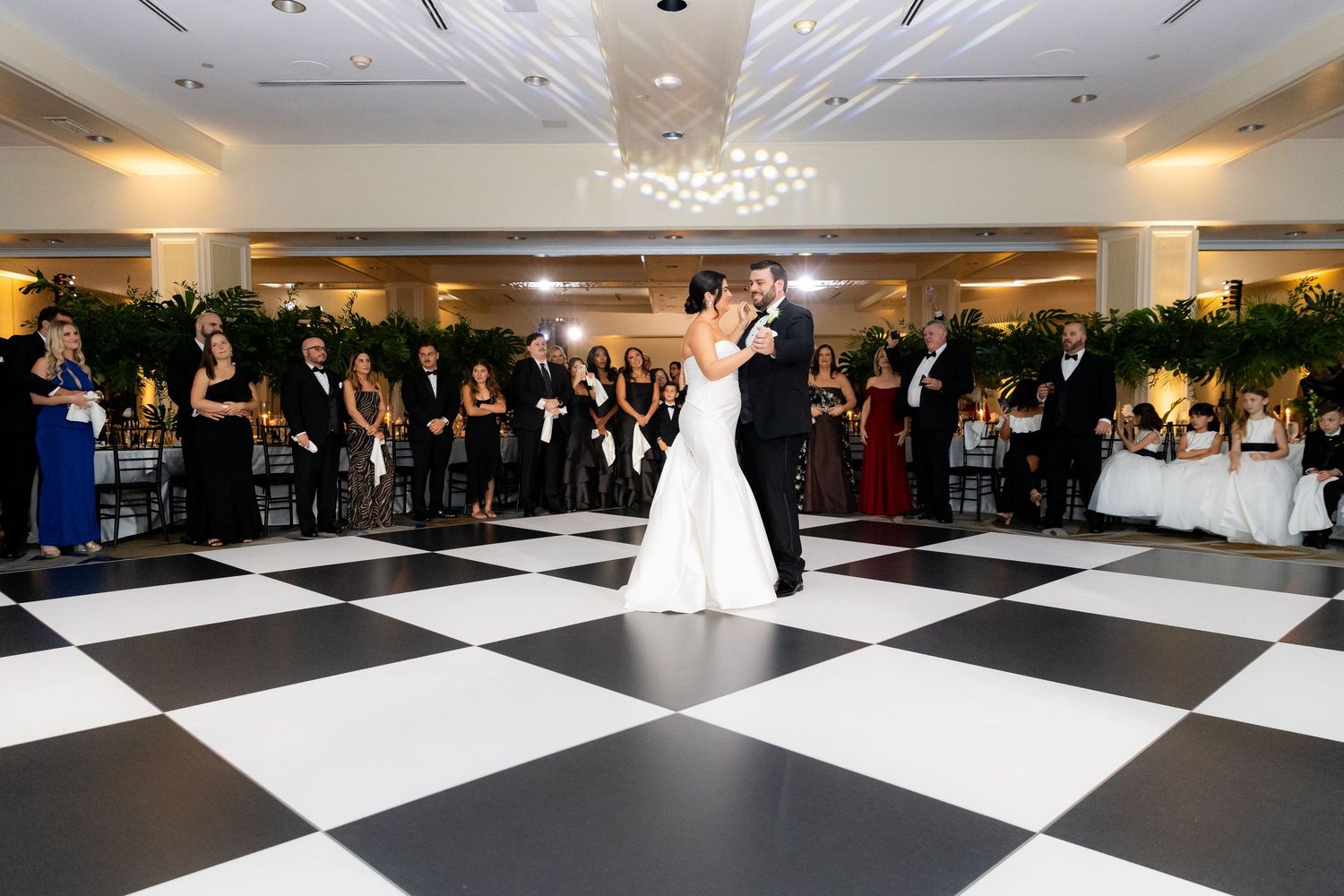Large ballroom with black and white checkered dance floor and crystal chandeliers.