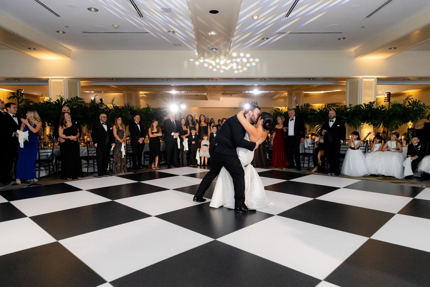 Large ballroom with black and white checkered dance floor set up for an elegant wedding reception.