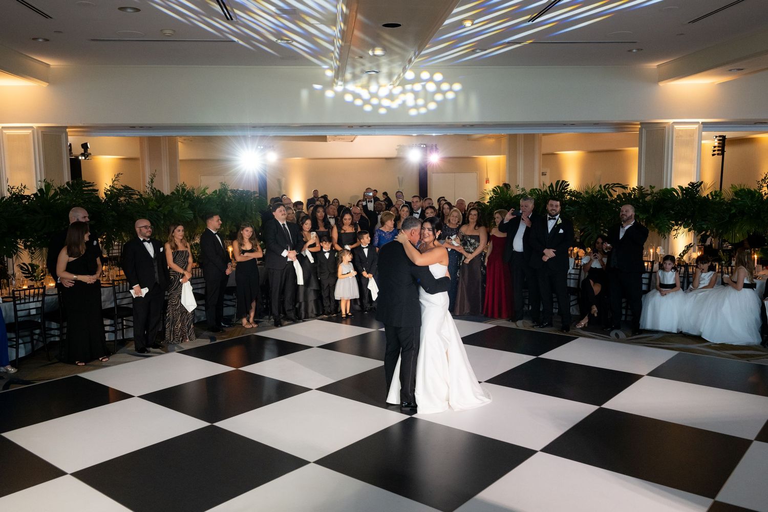 Wedding reception panorama showing black and white dance floor with guests dancing.