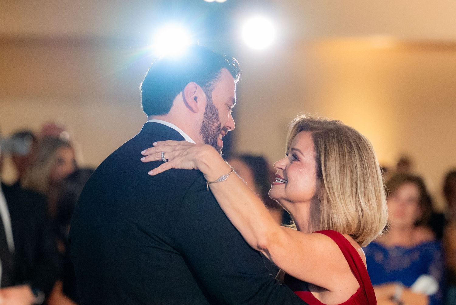 A tango dance class in progress as couples practice graceful movements under bright studio lights.