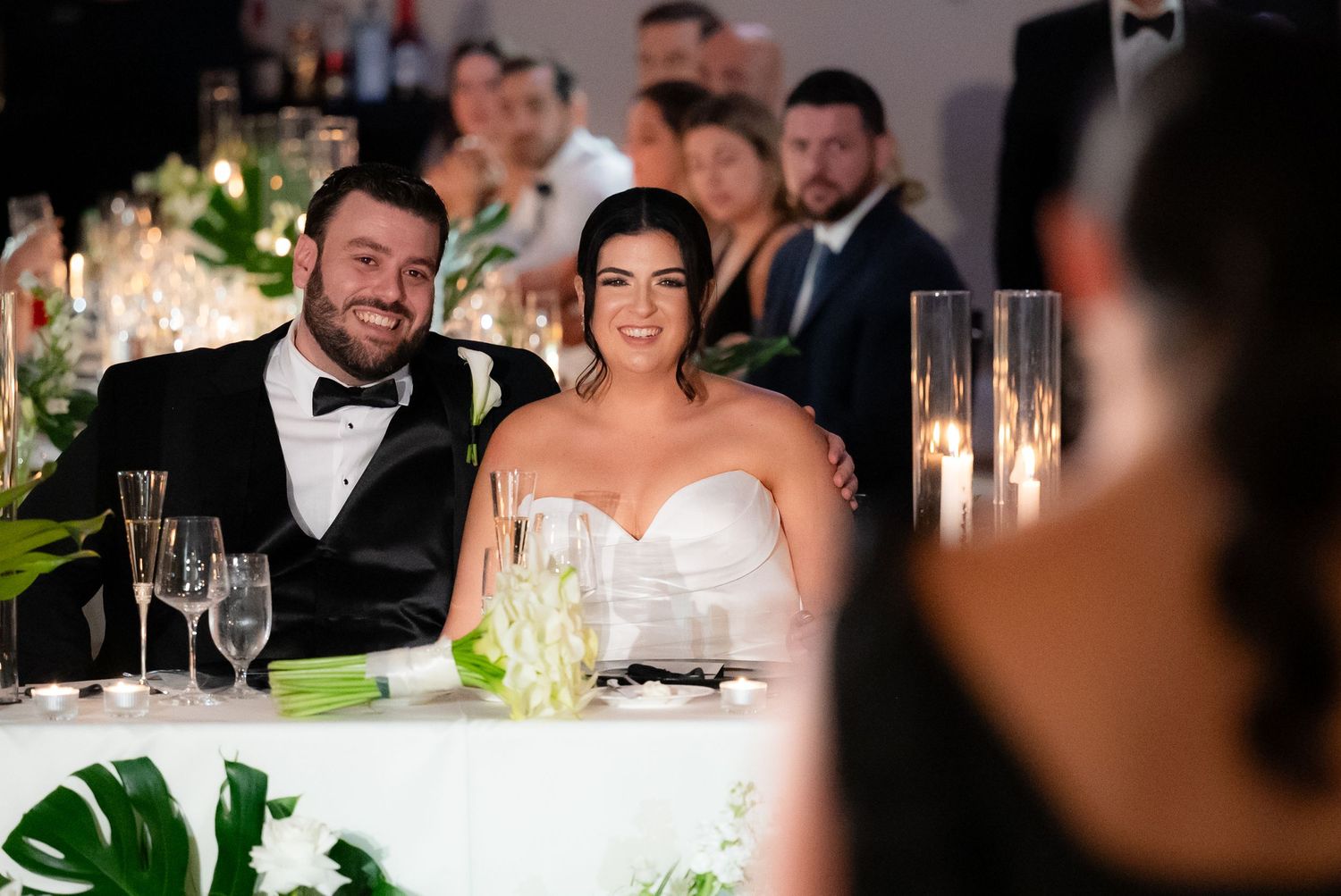 A sequence of wedding reception photos showing couples at an elegant candlelit dinner with white floral arrangements.