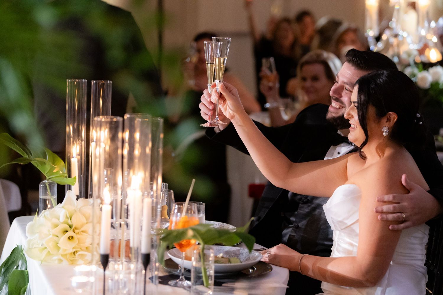 Wedding reception dance floor features couples dancing under elegant lighting and decor.
