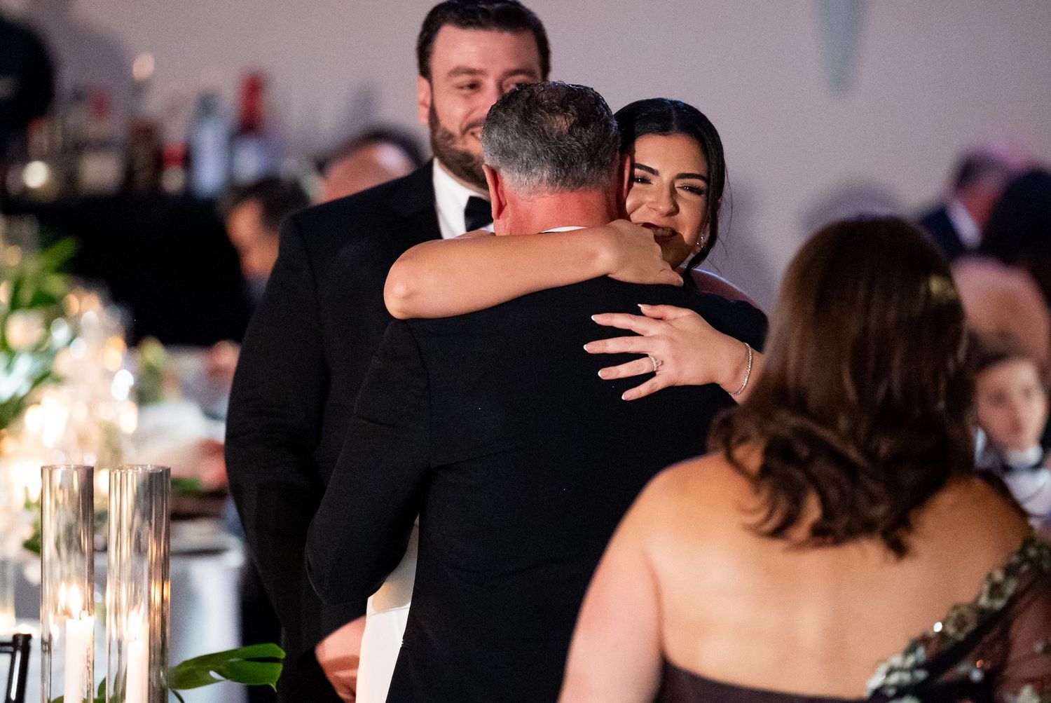 Emotional embrace shared between guests during a formal evening celebration.