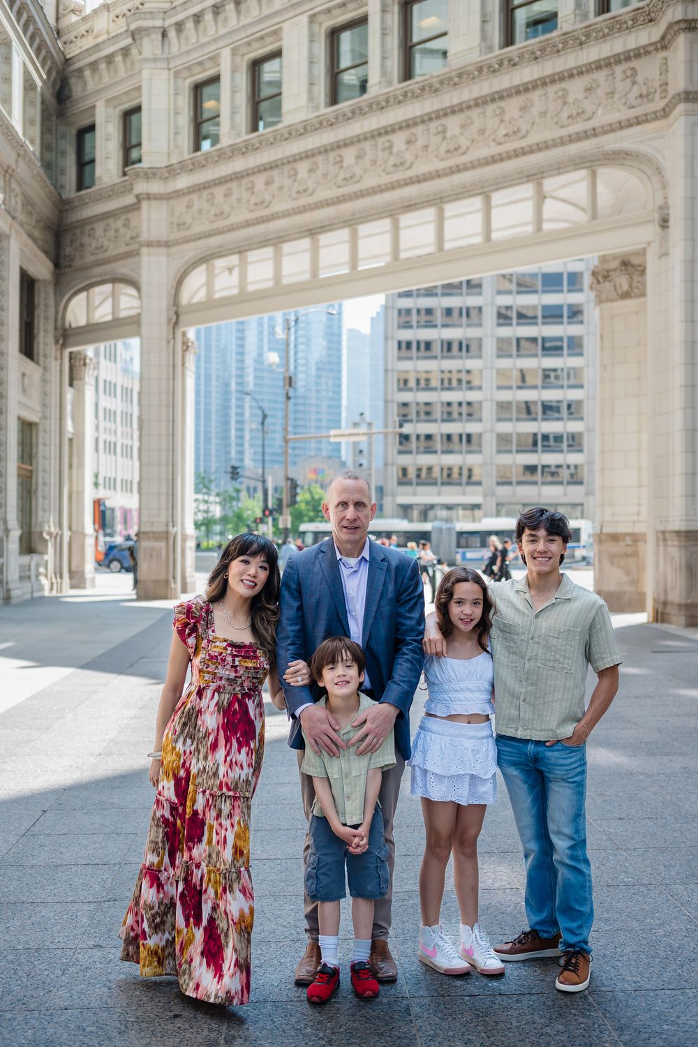 A family group poses together under an ornate archway of a historic building in downtown Chicago.