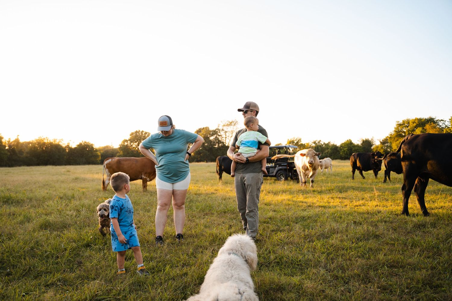 Family together in cow pasture during family documentary photography session near Tulsa, Oklahoma