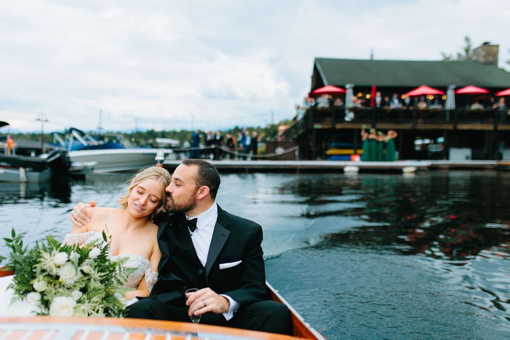 A romantic lakeside wedding celebration with boats and docks creating a scenic waterfront backdrop.