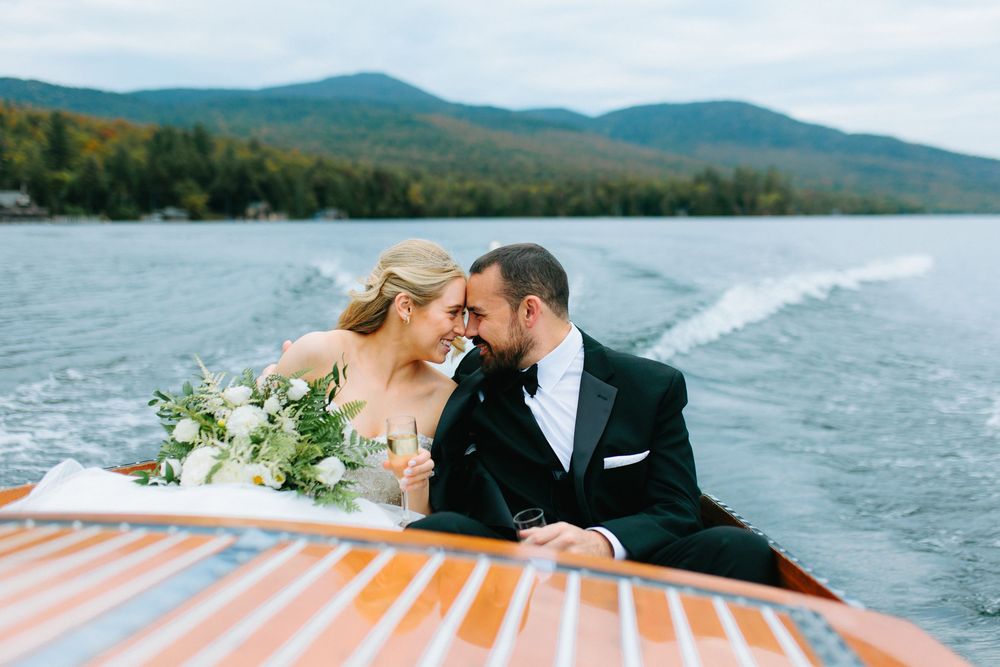 Romantic couple sharing intimate moments on a dock overlooking a scenic mountain lake.