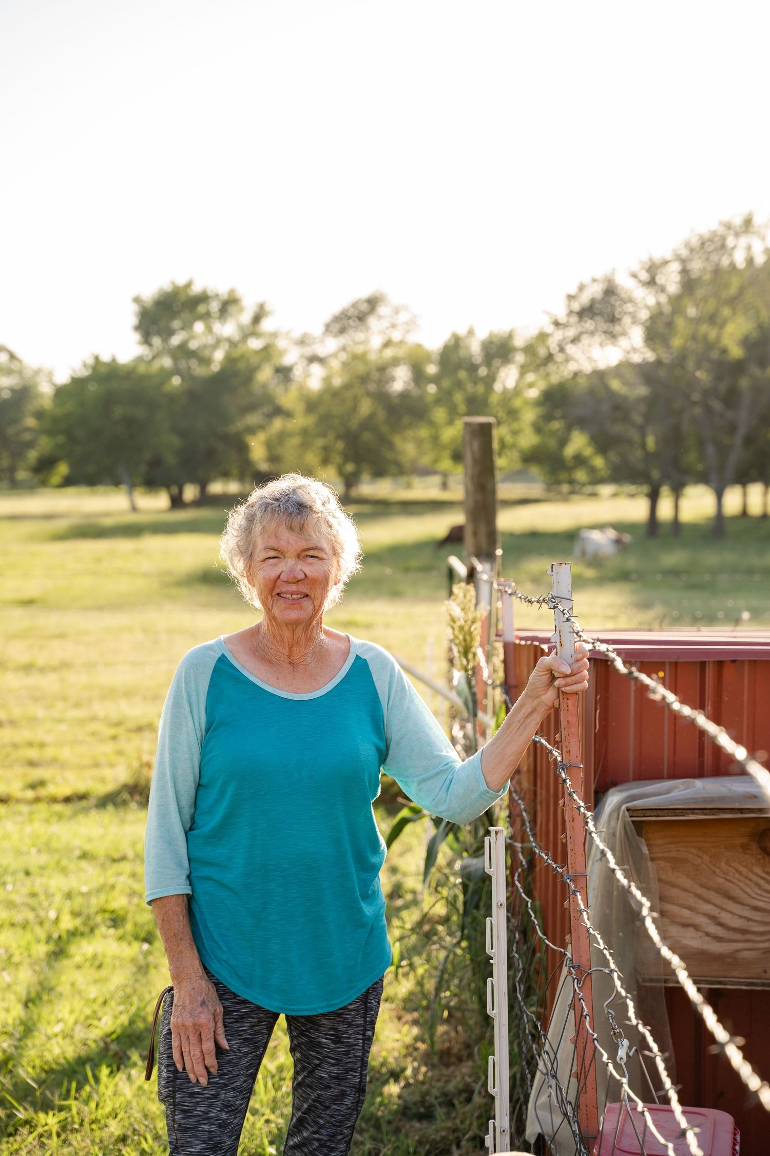 Tulsa photographer documents Grandma caring for the chickens on a hot day, part of a multigenerational family session.