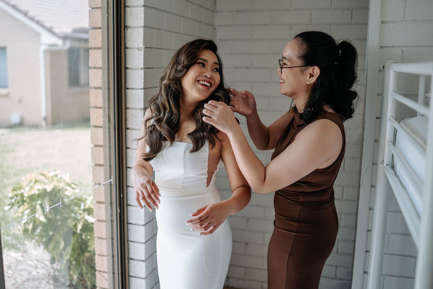 Two people embrace and laugh joyfully together during a casual lifestyle photoshoot at home.