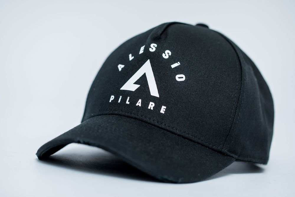 Black baseball cap with minimalist white mountain logo design shown from multiple angles.