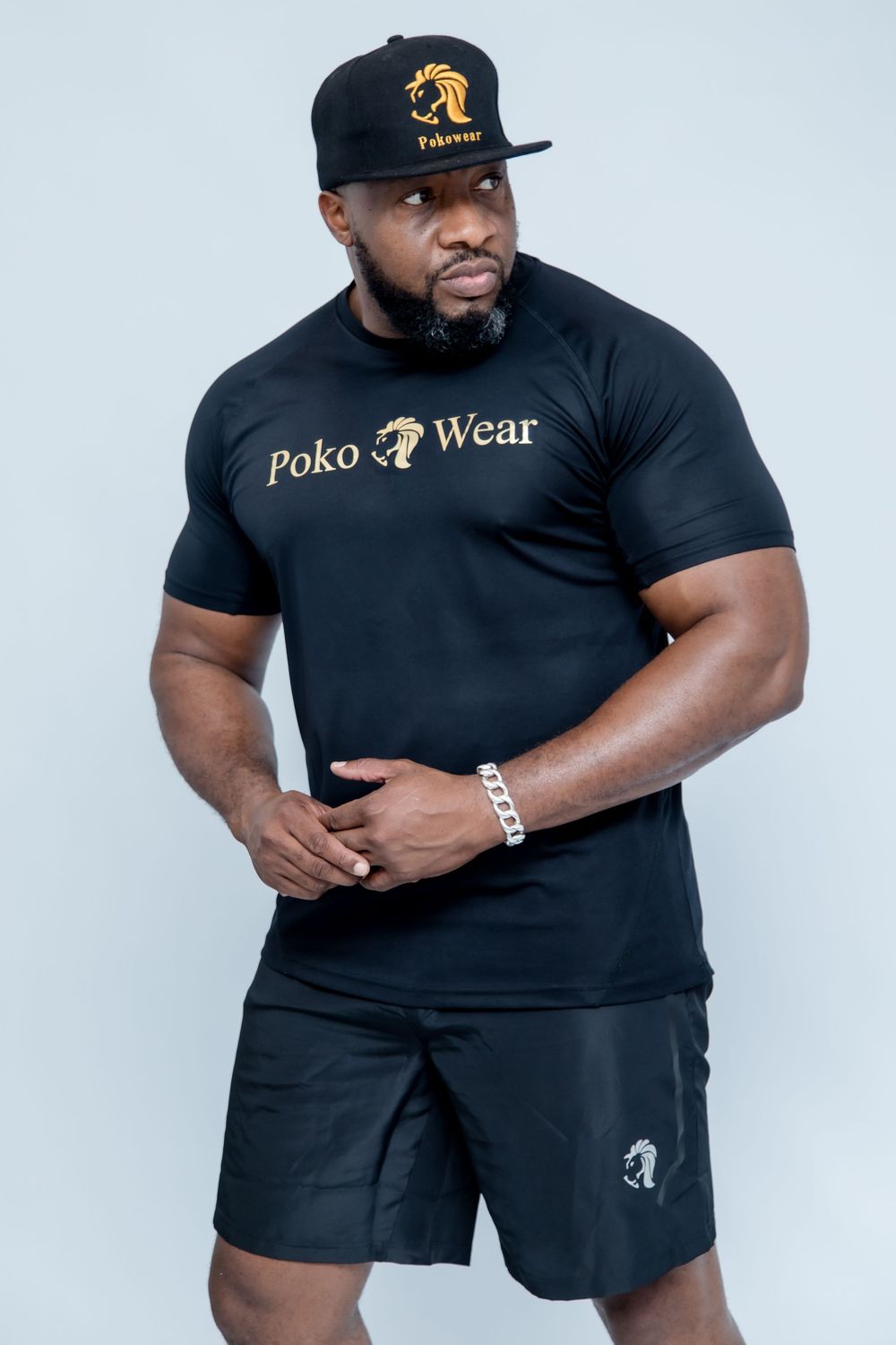 Athletic model showcases black Poko Wear sportswear collection against white background.