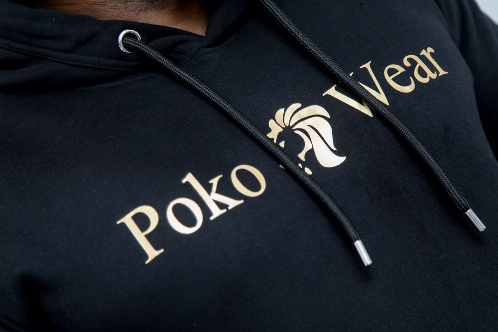 Closeup view of gold metallic text on a black surface showing partial lettering in elegant typography.