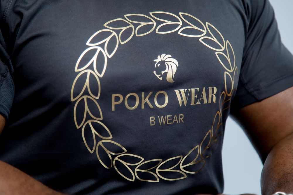 Black t-shirt with gold Poko Wear logo and laurel wreath design.