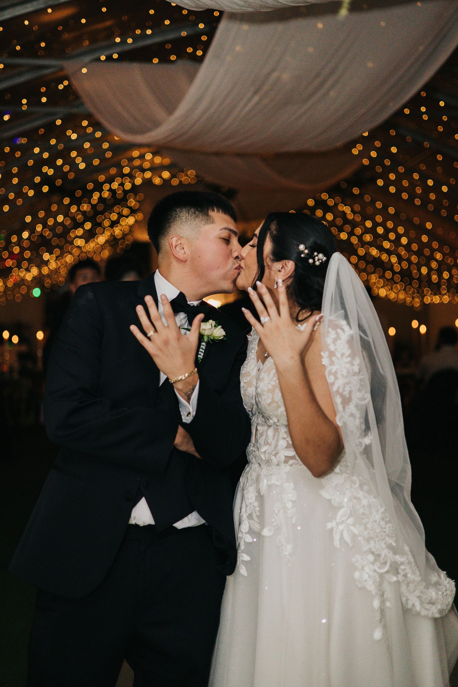 Wedding couple embraces and dances together during an emotional moment in a sunlit archway.