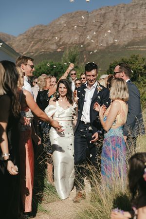 Bride and groom confetti toss at La Cotte in Franschhoek with mountain views
