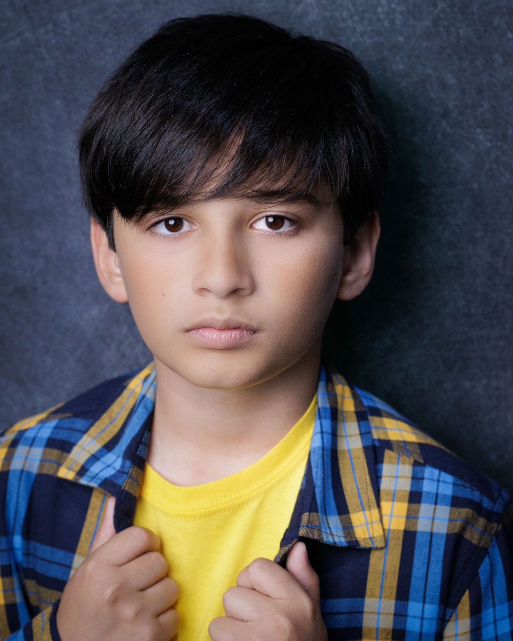 A portrait series shows someone wearing a yellow t-shirt and plaid blue shirt against a dark background.