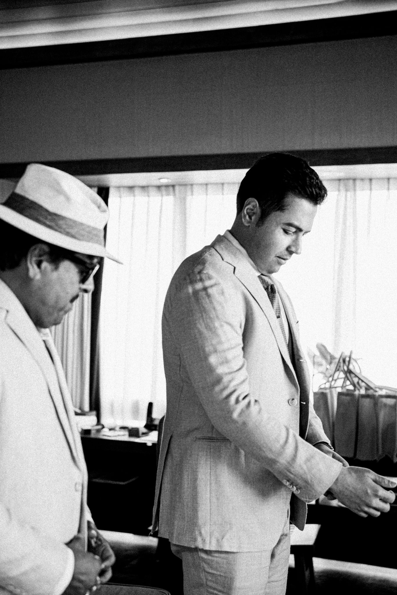 Black and white photos of groomsmen getting ready in formal attire.