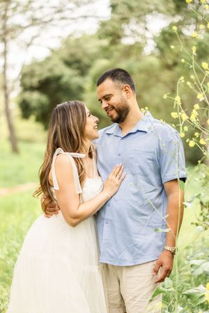 A loving couple shares intimate moments in a spring garden setting.
