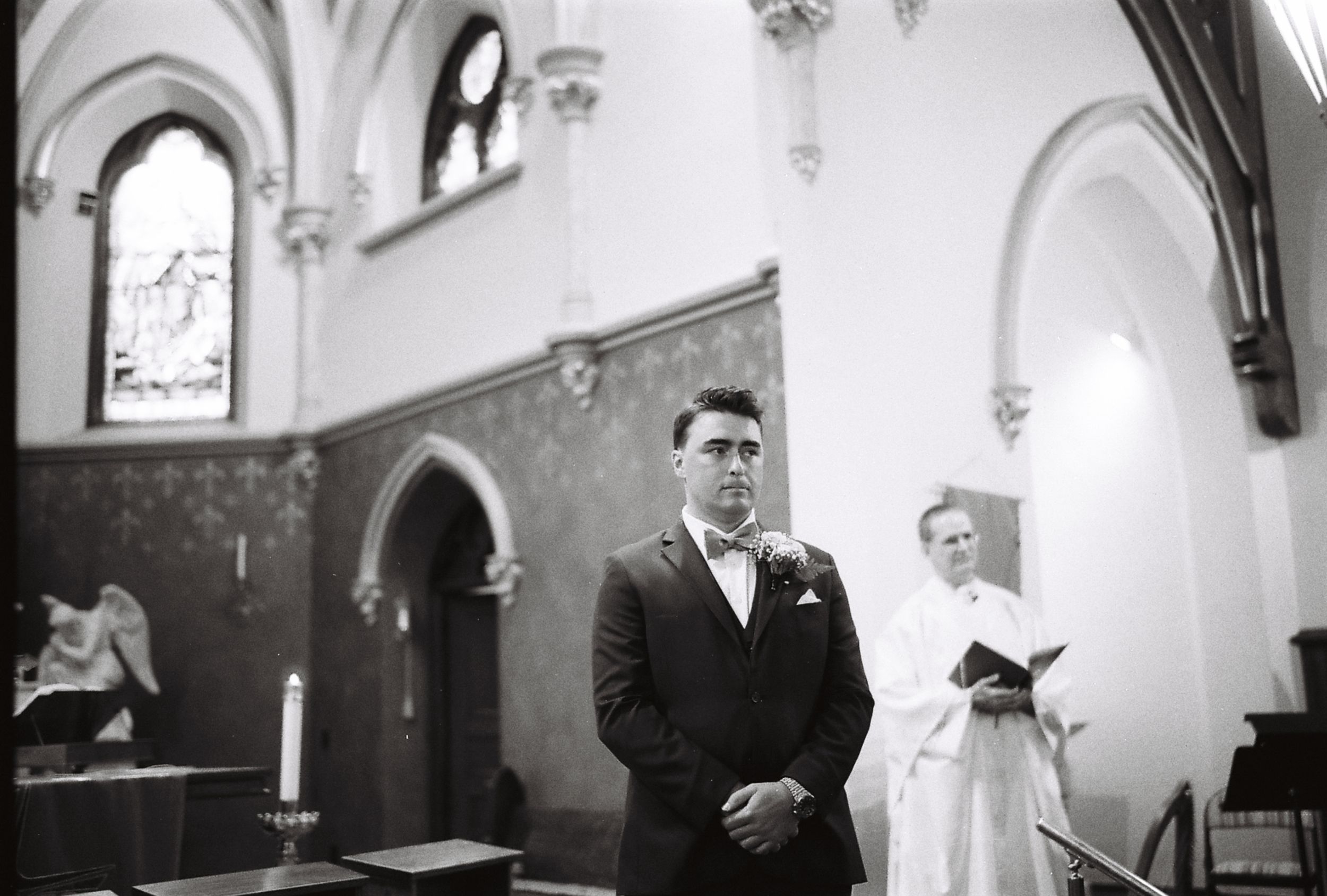 Black and white wedding ceremony photos showing the interior of a traditional church with Gothic architecture.