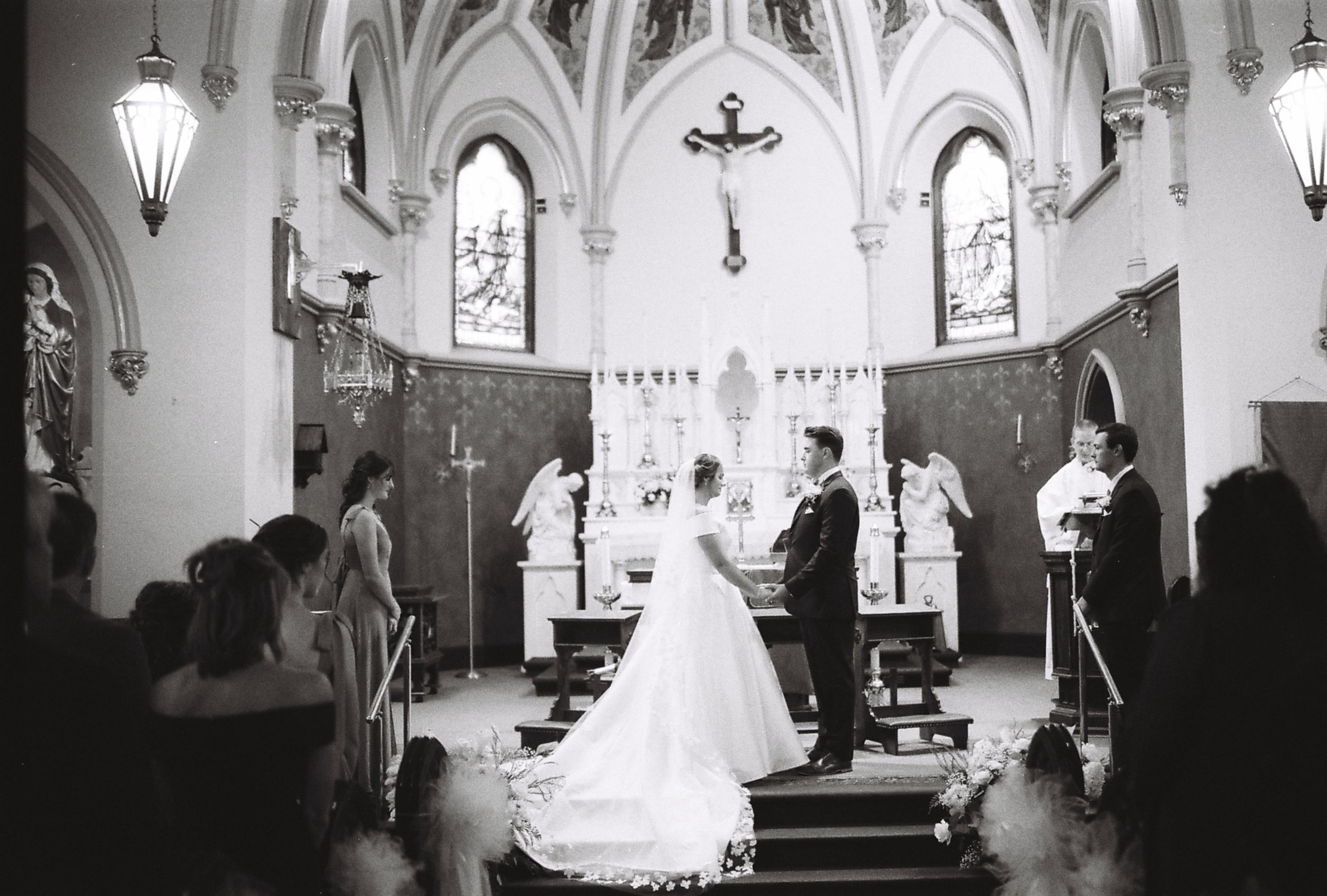 A series of black and white wedding photographs showing a bride in a church with elegant gothic architecture and stained glass windows.