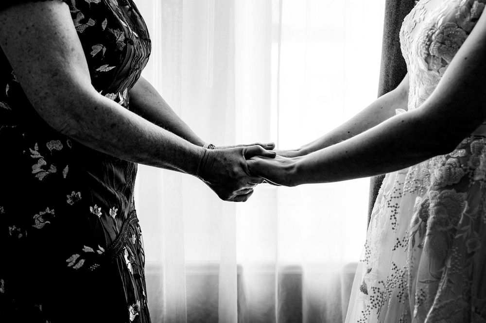Black and white photo collage showing intimate wedding moments with couples holding hands and embracing.