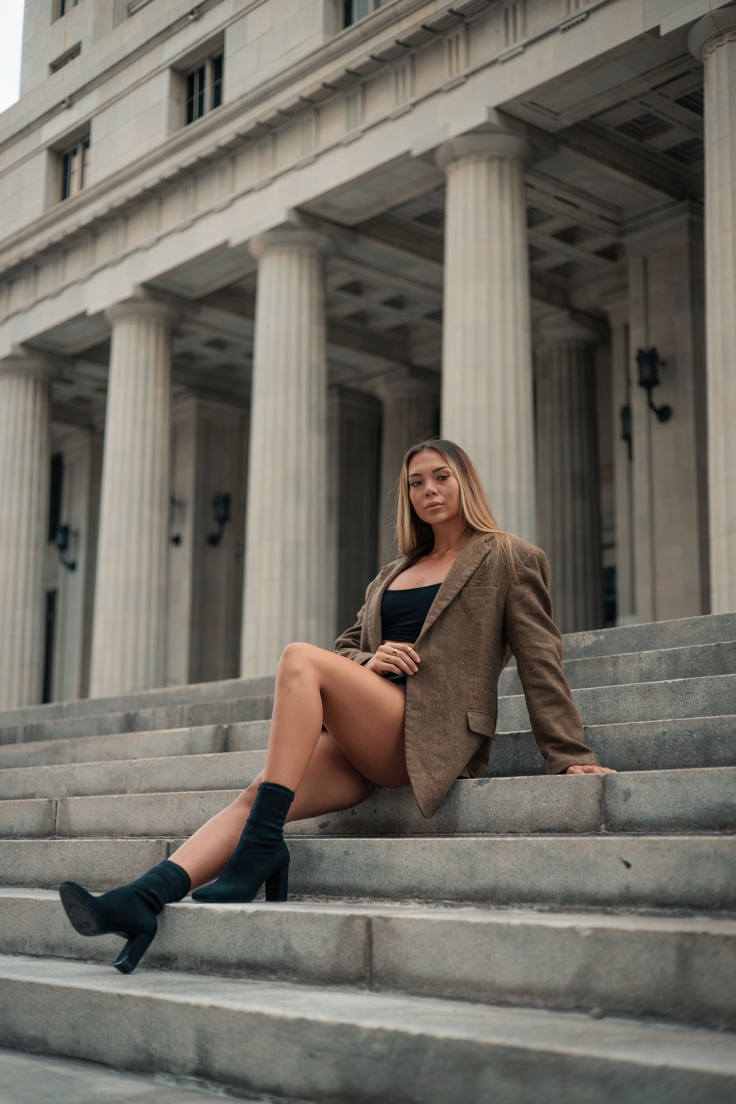 Editorial fashion portrait in West Palm Beach, woman seated in heels on stone steps, Vogue-inspired cinematic photography by Mannyportraits.