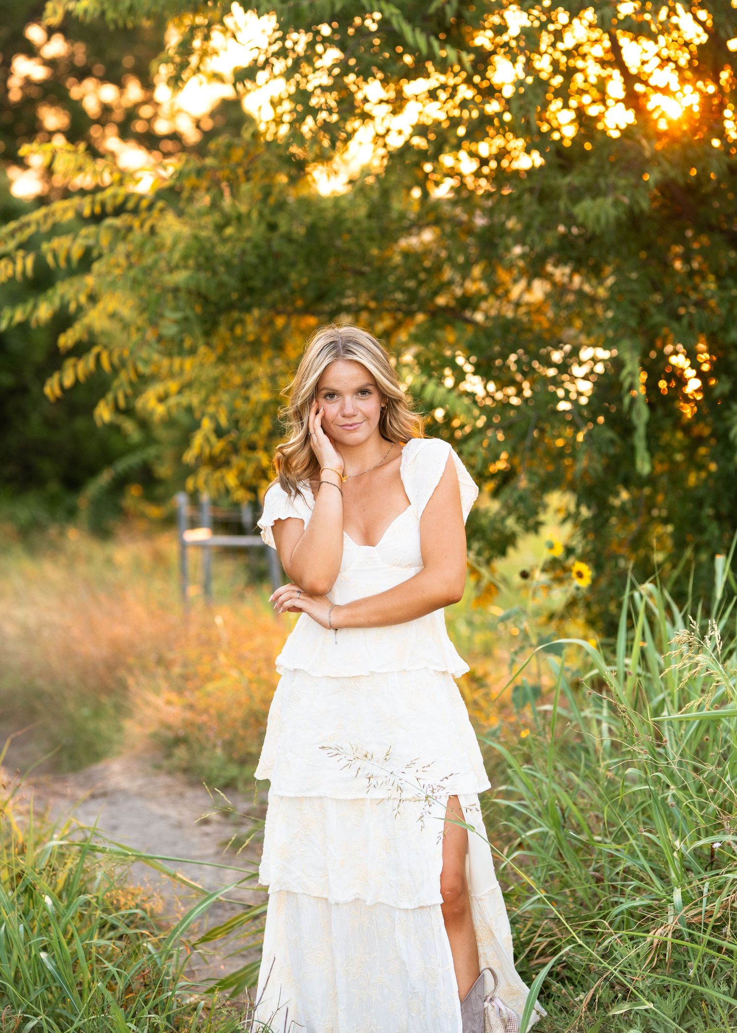 Lifestyle portraits captured at golden hour showing a figure in white dress amidst tall grass and sunset lighting.