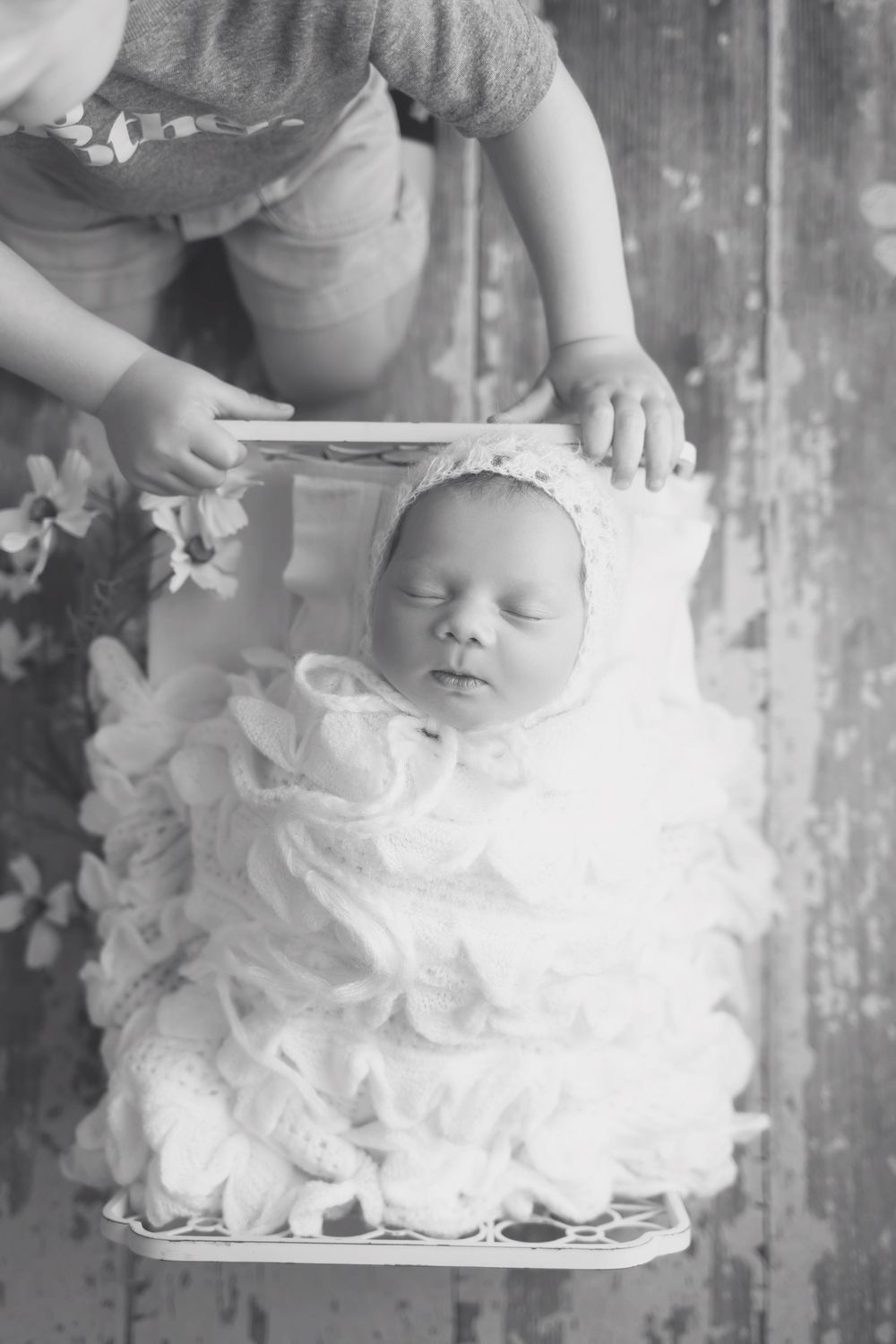 Baby girl in cream bed on wood floor, taken by Jen Knightstep, Photographer