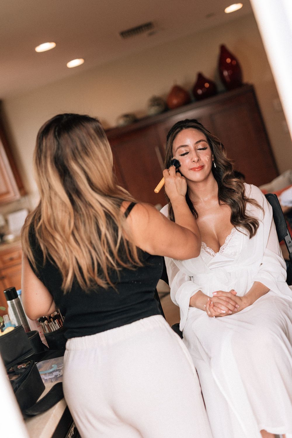 Bride finishing her makeup for her Malibu wedding on the California coast.