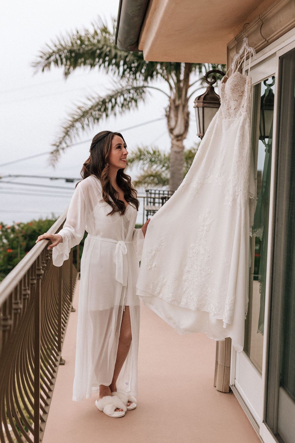 35mm film photo of the bride looking at her wedding dress in Malibu, California.