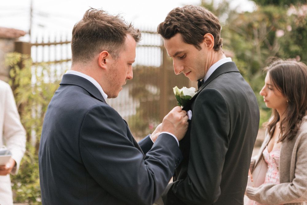 35mm film photo of the best man helping the groom with his boutonniere in Malibu.