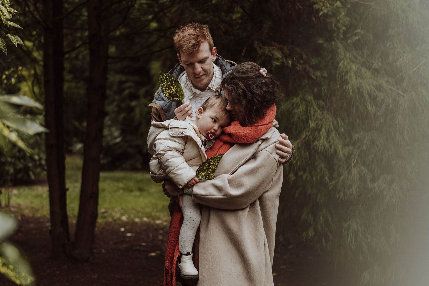 A couple in romantic outdoor forest setting with moody lighting and atmospheric fog effect.