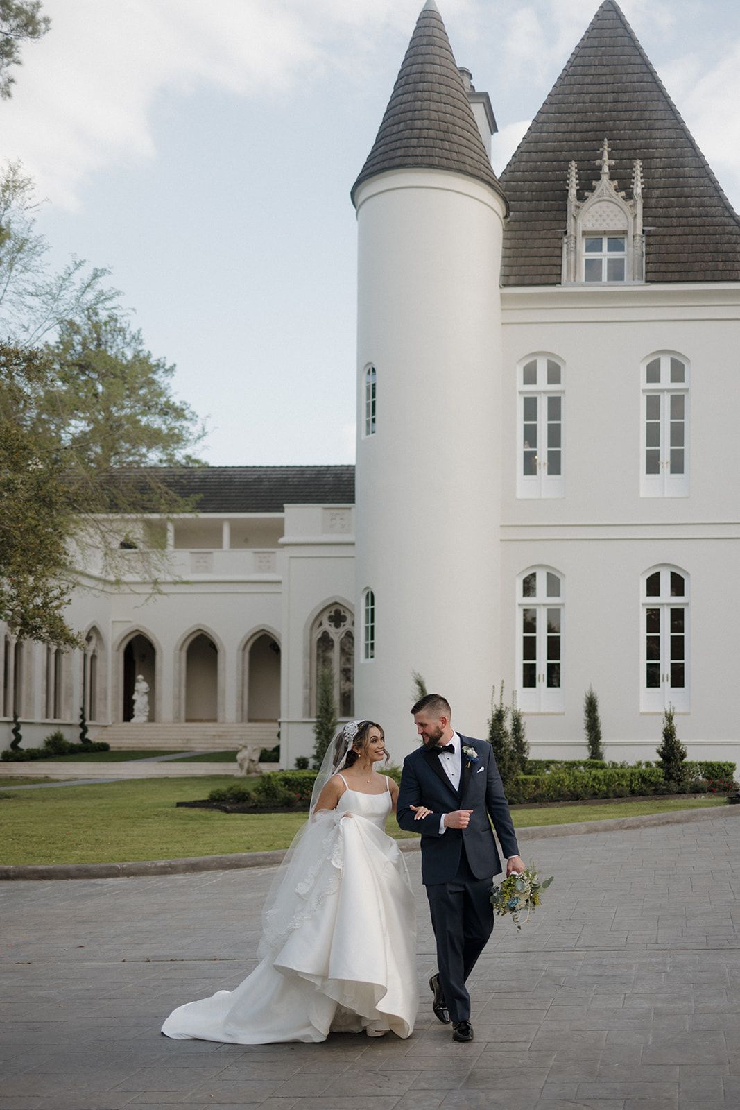 Bride and groom walking together outside of Chateau Nouvelle in Houston, Tx