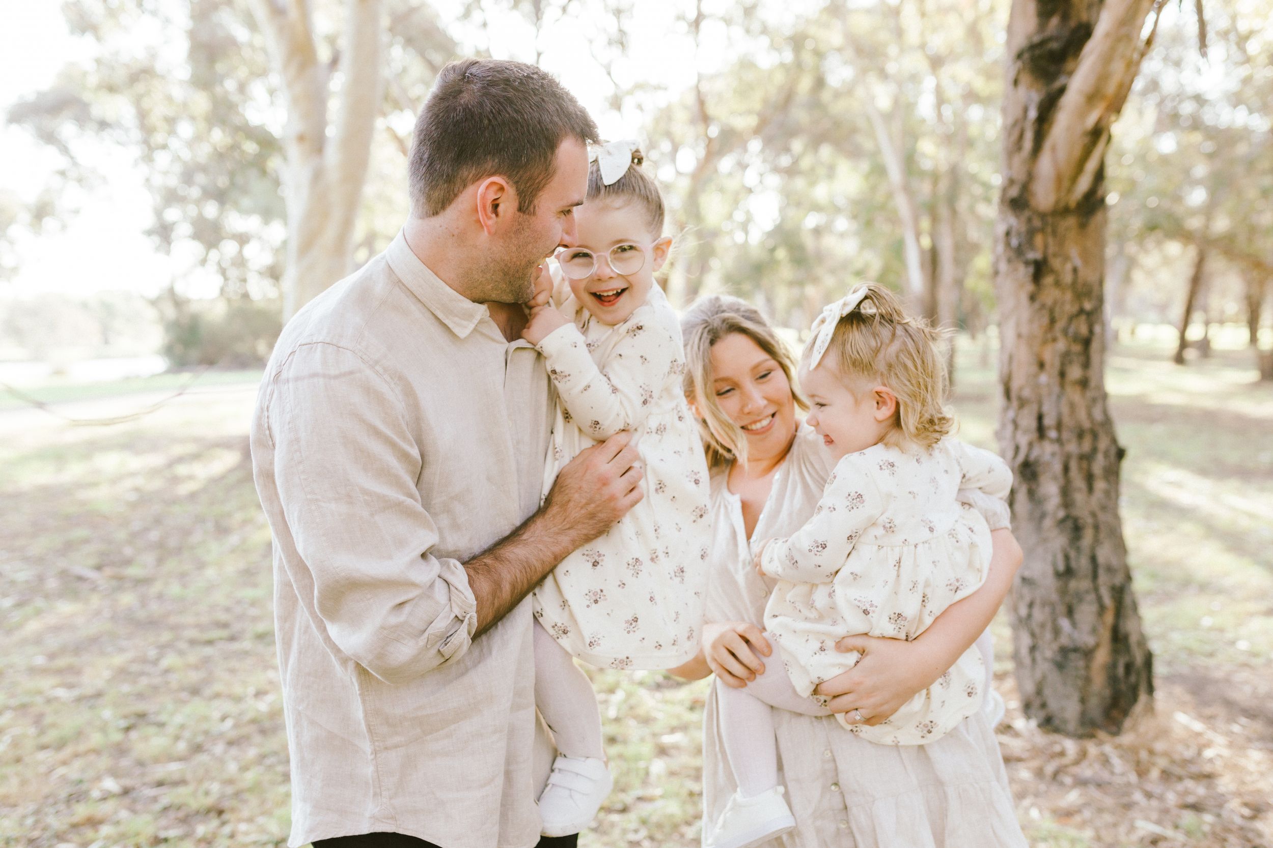 Loving couple shares tender moments together outdoors in a sun-drenched forest setting.