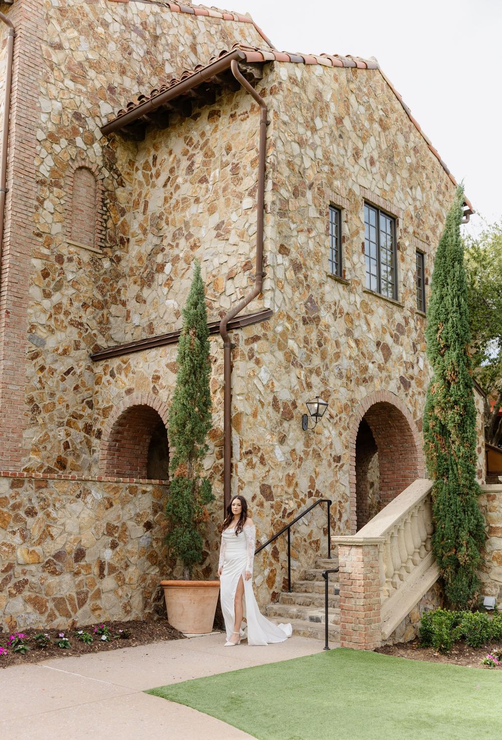 A rustic Tuscan villa entrance with stone walls, tall arches, and climbing vines sets a romantic Mediterranean ambiance.