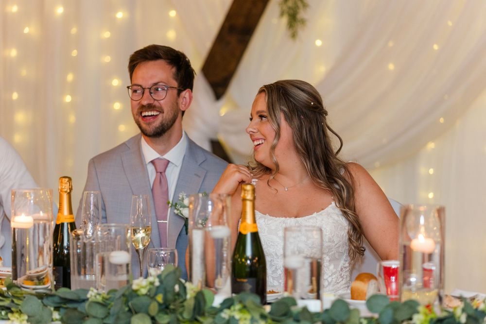 Wedding reception venue decorated with string lights and white drapery creating romantic ambiance.