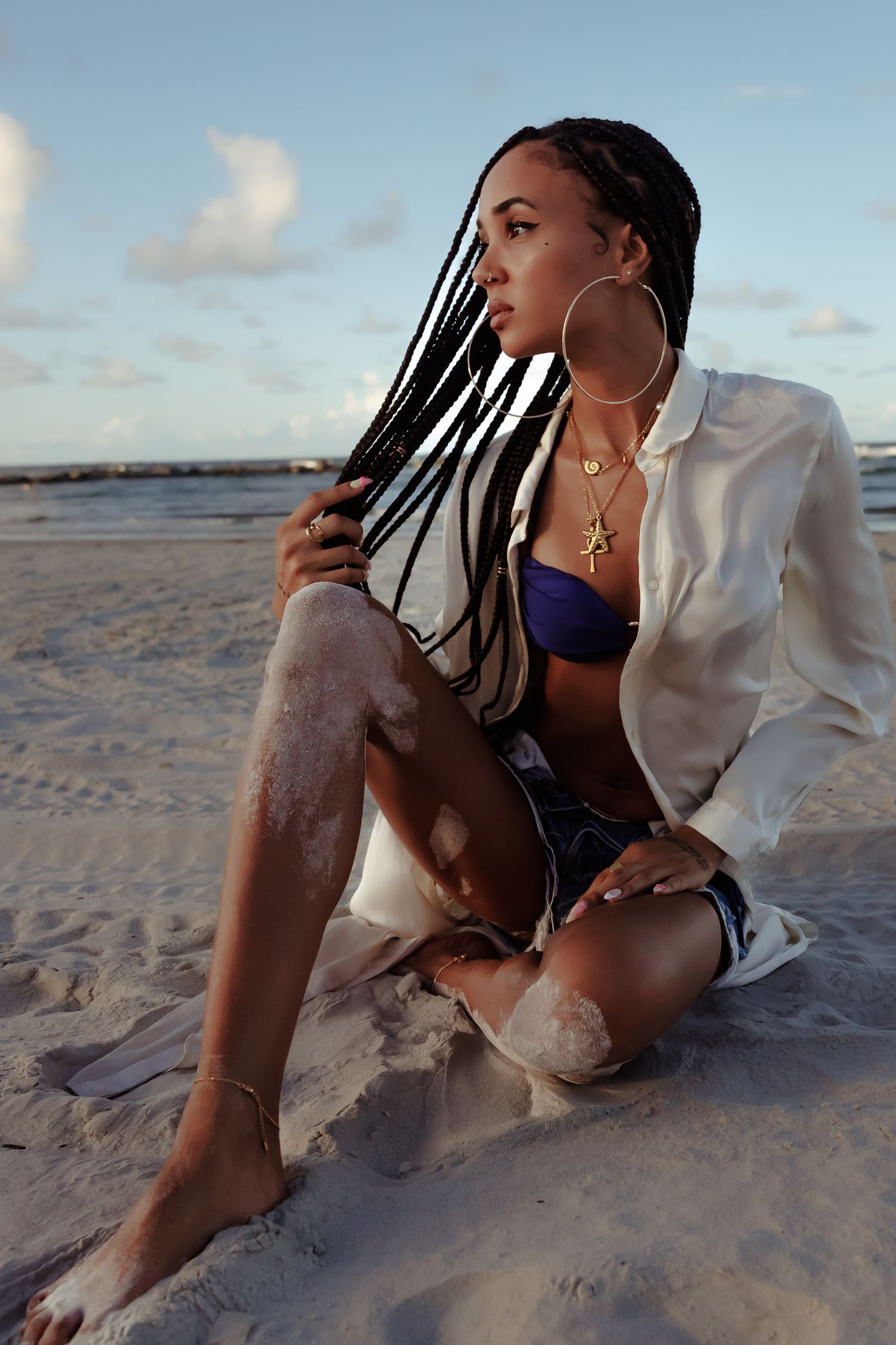 A series of beach photos showing a person in a white jacket posing on sandy shores at sunset.