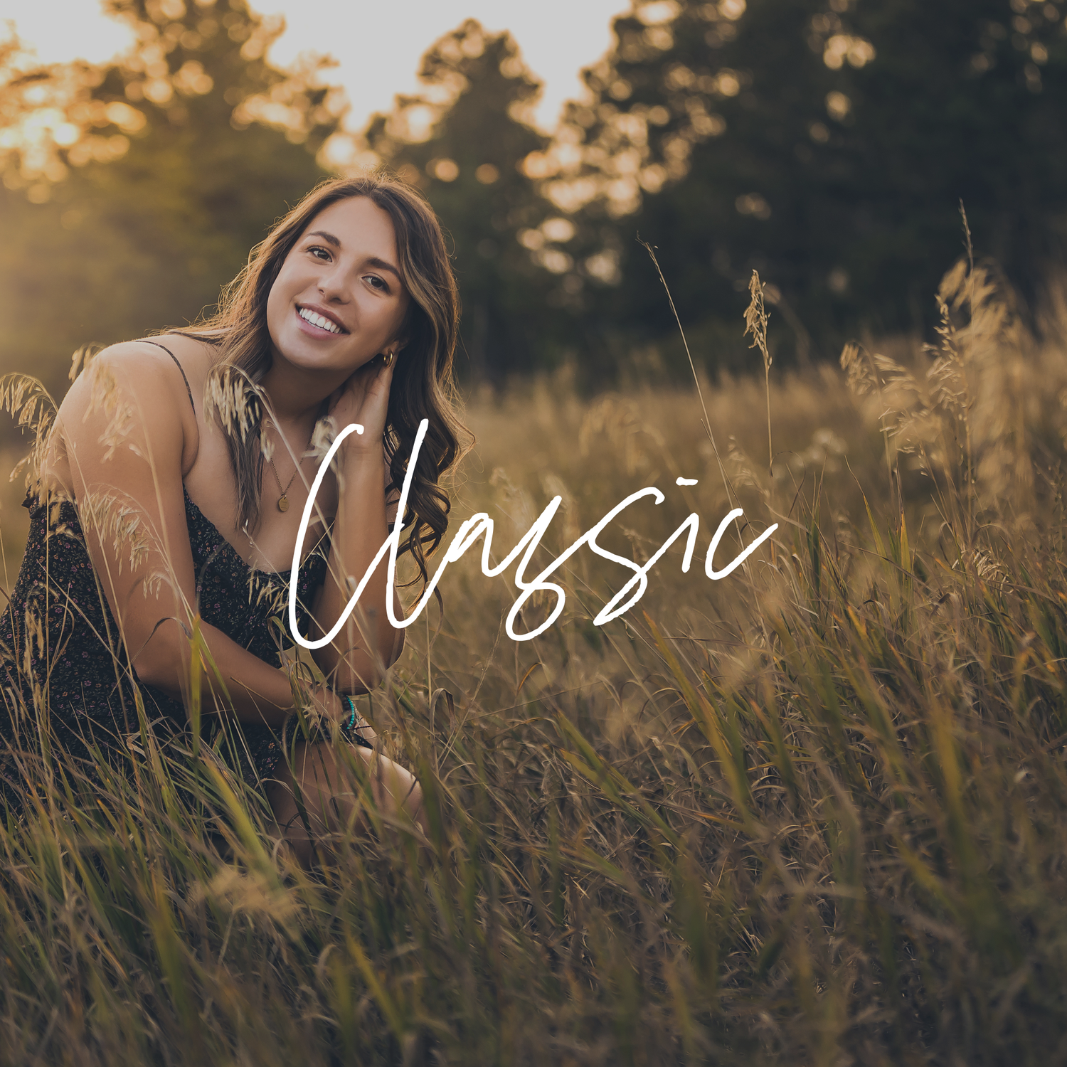A person smiles joyfully while sitting in a golden field of tall grass during sunset.